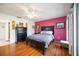 Well-lit bedroom featuring hardwood floors, a bright accent wall, and a comfortable queen-sized bed at 3662 Bonaventure Ct, Sarasota, FL 34243