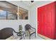 Inviting front porch with seating area, red door, and a decorative tiki statue at 3662 Bonaventure Ct, Sarasota, FL 34243