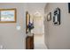 Neutral hallway with tile flooring, decorated with wall art and a decorative cabinet at 3662 Bonaventure Ct, Sarasota, FL 34243