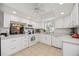 Open kitchen with white cabinets, granite countertops, tile floors, and stainless-steel appliances at 3662 Bonaventure Ct, Sarasota, FL 34243
