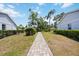 Paver path between villas, leading through the yard with green grass and landscaping at 3662 Bonaventure Ct, Sarasota, FL 34243