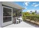 Outdoor patio featuring a seating area, mature shrubs, and access to the screened-in patio at 3662 Bonaventure Ct, Sarasota, FL 34243