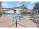 Enclosed community pool and hot tub area with lounge chairs, net, and tile flooring at 3662 Bonaventure Ct, Sarasota, FL 34243
