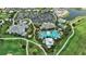 Aerial view of a stunning community with a large pool, clubhouse, and surrounding greenery at 3679 Santa Caterina Blvd, Bradenton, FL 34211