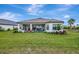 Spacious backyard featuring a covered patio with an outdoor kitchen, comfortable seating, and lush green grass at 3679 Santa Caterina Blvd, Bradenton, FL 34211