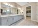 This modern bathroom includes a double sink vanity, large mirror, and access to the walk-in closet at 3679 Santa Caterina Blvd, Bradenton, FL 34211