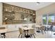 Cafe featuring rustic wood paneled wall with shelves, and tables with modern chairs for a comfortable dining experience at 3679 Santa Caterina Blvd, Bradenton, FL 34211