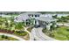 Stunning exterior view of a home with a circular driveway and covered entrance, enhanced by lush landscaping and a lake view at 3679 Santa Caterina Blvd, Bradenton, FL 34211