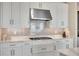 The kitchen features white cabinets with a gray backsplash and stainless steel appliances at 3679 Santa Caterina Blvd, Bradenton, FL 34211
