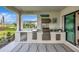 Outdoor kitchen featuring stainless steel appliances, granite countertop, and a cozy rug, perfect for outdoor cooking at 3679 Santa Caterina Blvd, Bradenton, FL 34211