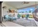 Outdoor living space features comfortable seating, a mounted TV, and a cozy hanging chair overlooking the backyard at 3679 Santa Caterina Blvd, Bradenton, FL 34211