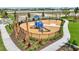 A fenced-in neighborhood playground features modern blue play structures, lush landscaping, and a wood chip safety surface at 3679 Santa Caterina Blvd, Bradenton, FL 34211