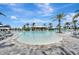 Resort-style pool with Baja shelf, lounge chairs, umbrellas, and the Bahama Bar in the background on a sunny day at 3679 Santa Caterina Blvd, Bradenton, FL 34211