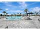 A beautiful pool with lounge chairs, umbrellas, and palm trees in a resort-style setting on a bright, sunny day at 3679 Santa Caterina Blvd, Bradenton, FL 34211