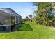 The spacious backyard features lush grass and a screened lanai, offering a perfect blend of indoor/outdoor living at 3740 Summerwind Cir, Bradenton, FL 34209