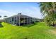 A view of the house exterior with the screened lanai extending to the well-kept lawn in the backyard at 3740 Summerwind Cir, Bradenton, FL 34209
