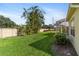 The spacious backyard has lush green grass and partial view of the screened in lanai and exterior at 3740 Summerwind Cir, Bradenton, FL 34209