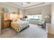 Cozy bedroom with a tray ceiling, window, carpet floors and built in storage space at 3740 Summerwind Cir, Bradenton, FL 34209