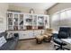 Inviting home office with custom shelving, wood-look floors, and a relaxing seating arrangement at 3740 Summerwind Cir, Bradenton, FL 34209