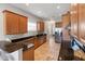 Modern kitchen featuring black countertops, stainless steel appliances, and natural wood cabinetry at 3740 Summerwind Cir, Bradenton, FL 34209