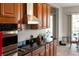 A kitchen featuring wood cabinets, black countertops, stainless steel appliances, and an exhaust hood at 3740 Summerwind Cir, Bradenton, FL 34209