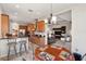 Open concept kitchen features breakfast bar, wood cabinets, pendant lighting, and adjacent dining area at 3740 Summerwind Cir, Bradenton, FL 34209