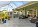 The screened lanai features tile flooring, comfortable seating, and tranquil views of the outdoors at 3740 Summerwind Cir, Bradenton, FL 34209