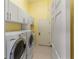 Well-lit laundry room featuring modern appliances, white cabinets and ample storage at 3740 Summerwind Cir, Bradenton, FL 34209