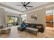 Spacious living room with a tile floor, a ceiling fan, and sliding glass doors that lead to a patio at 3740 Summerwind Cir, Bradenton, FL 34209