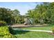 Community playground with climbing structure and swings surrounded by green space at 3740 Summerwind Cir, Bradenton, FL 34209