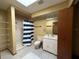 Bathroom featuring shower with blue striped curtains, tile flooring, and off white sink at 3957 Bearded Oaks Ct, Sarasota, FL 34232