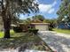 Charming single-story home with a well-manicured lawn, mature trees, and a spacious driveway leading to an attached garage at 3957 Bearded Oaks Ct, Sarasota, FL 34232