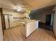 Bright kitchen with white cabinets and an island, seamlessly connecting to an adjacent dining area with tile floors at 3957 Bearded Oaks Ct, Sarasota, FL 34232