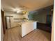 Bright kitchen with white cabinets and an island, seamlessly connecting to an adjacent dining area with tile floors at 3957 Bearded Oaks Ct, Sarasota, FL 34232