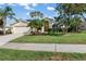 Inviting single-story home featuring a well-manicured lawn and tropical palm trees at 4063 Westbourne Cir, Sarasota, FL 34238