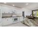 Well-lit kitchen featuring modern appliances, granite countertops and white cabinetry at 4063 Westbourne Cir, Sarasota, FL 34238