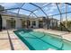 Relaxing in-ground pool featuring a screened enclosure and patio area at 4063 Westbourne Cir, Sarasota, FL 34238
