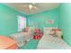 Cozy ' bedroom with twin beds, stuffed animals, colorful decor, and teal walls at 4211 30Th E Ln, Bradenton, FL 34208