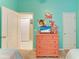 Bright bedroom featuring a pastel-painted dresser with beach themed decor, creating a cozy and playful atmosphere at 4211 30Th E Ln, Bradenton, FL 34208
