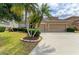 An inviting, tan home has a large driveway leading to a three-car garage surrounded by manicured landscaping and healthy trees at 4211 30Th E Ln, Bradenton, FL 34208
