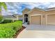 Beautiful landscaping frames this tan home, highlighting the home's architecture and well-manicured lawn at 4211 30Th E Ln, Bradenton, FL 34208