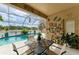 Relaxing outdoor patio with a dining table, overlooking the sparkling pool and serene water view at 4211 30Th E Ln, Bradenton, FL 34208