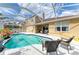 Backyard pool area featuring a screened enclosure, waterfront view, and comfortable seating at 4211 30Th E Ln, Bradenton, FL 34208