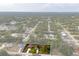 Expansive aerial view of a single-Gathering home featuring a long driveway and a well-manicured lawn surrounded by lush greenery at 4466 Manila Ave, North Port, FL 34288