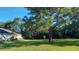 The home's backyard features a lush lawn and mature trees, creating a serene and private space at 4466 Manila Ave, North Port, FL 34288