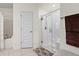 Bright bathroom featuring walk-in shower, soaking tub, tiled floors, and towel rack at 4466 Manila Ave, North Port, FL 34288
