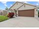 Front exterior featuring a paved driveway and well-maintained landscaping near the two-car garage at 4466 Manila Ave, North Port, FL 34288
