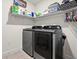 Convenient laundry area with modern gray washer and dryer and shelf space for supplies at 4466 Manila Ave, North Port, FL 34288