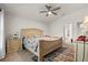 Bright main bedroom featuring a ceiling fan, ensuite bathroom, and carpet flooring at 4466 Manila Ave, North Port, FL 34288