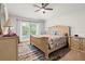Bright main bedroom featuring a ceiling fan, carpet flooring, and side tables at 4466 Manila Ave, North Port, FL 34288
